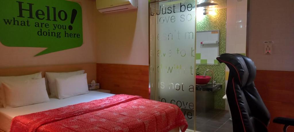 a bedroom with a bed and a sign on the wall at Design T Motel in Ulsan