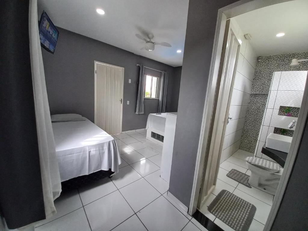 a small bathroom with a bed and a shower at Recanto Familiar in Monte das Gameleiras