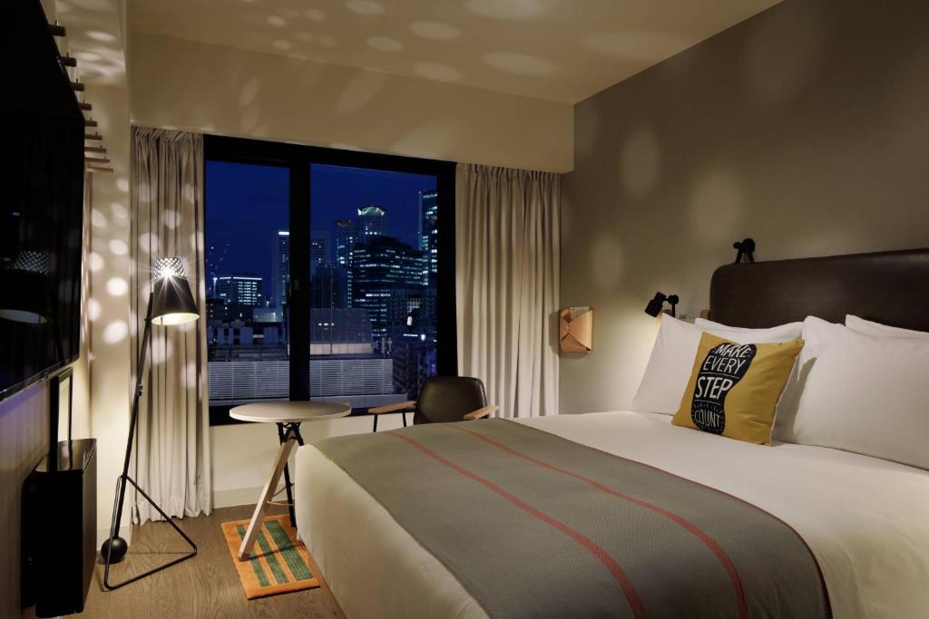 Postel nebo postele na pokoji v ubytování Moxy Osaka Umeda