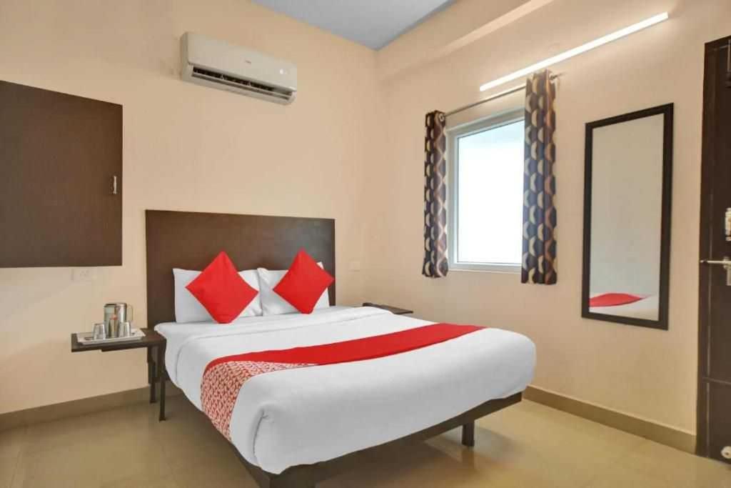 a bedroom with a large bed with red pillows at OYO Flagship ELEGANT RESIDENCY in Chennai