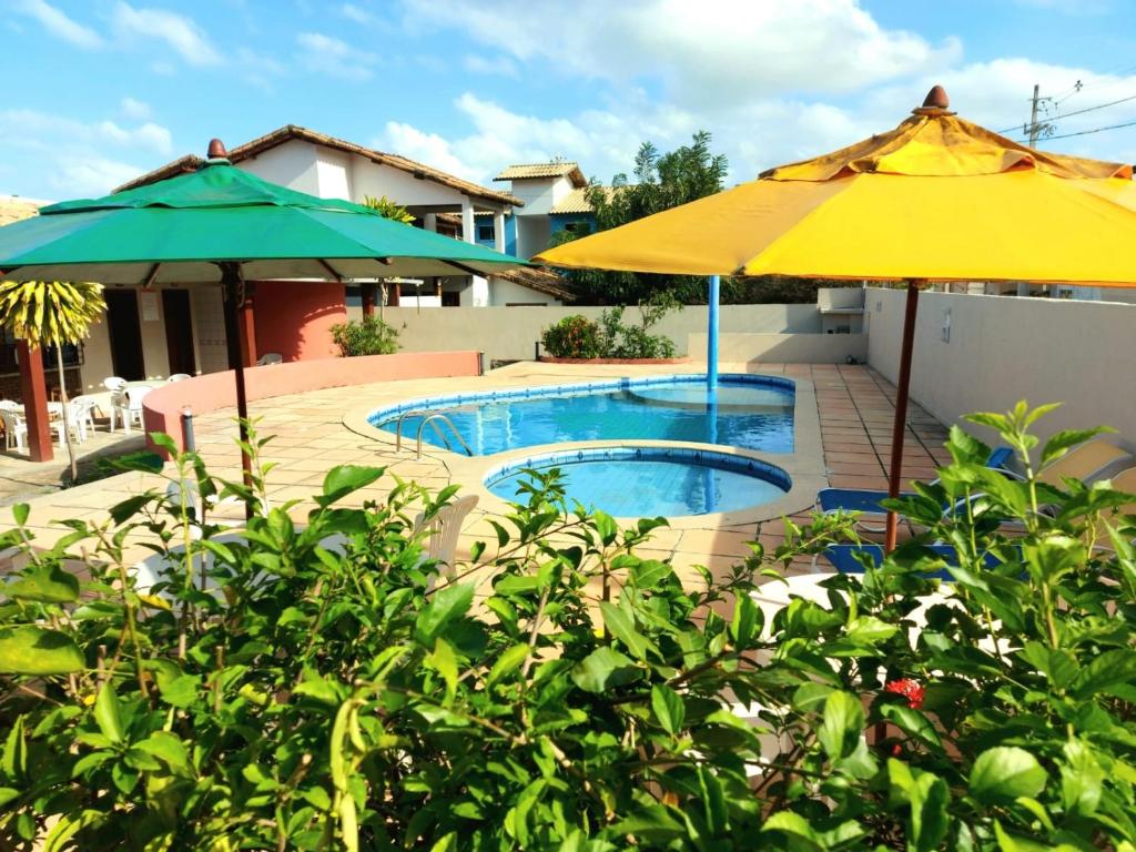 - Piscina con 2 sombrillas en Branca Tropical Brasil Residencial- Taperapuan, en Porto Seguro