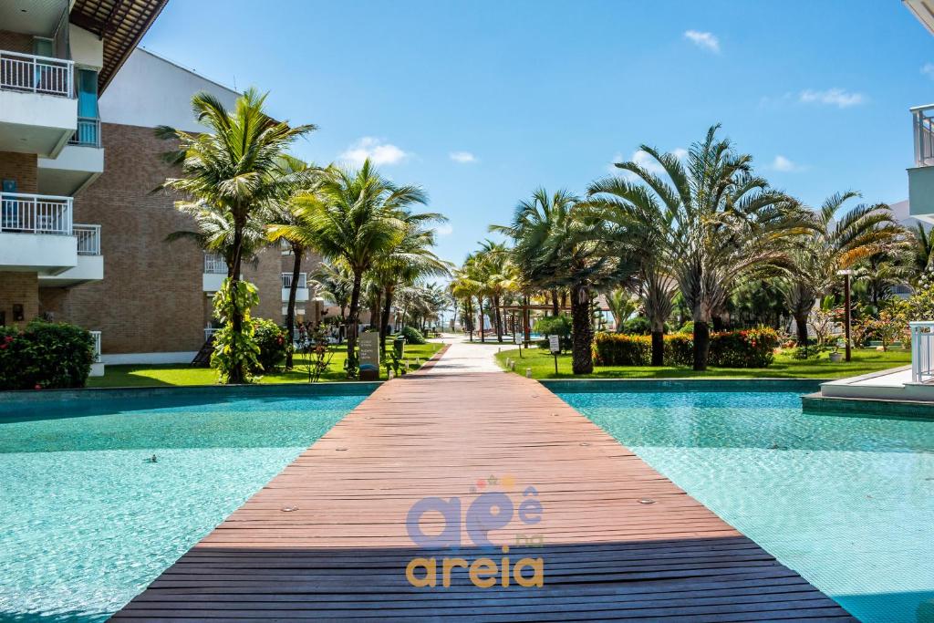 a walkway leading to a swimming pool at a resort at O Apê na Areia é seu refúgio pertinho do Beach Park in Aquiraz
