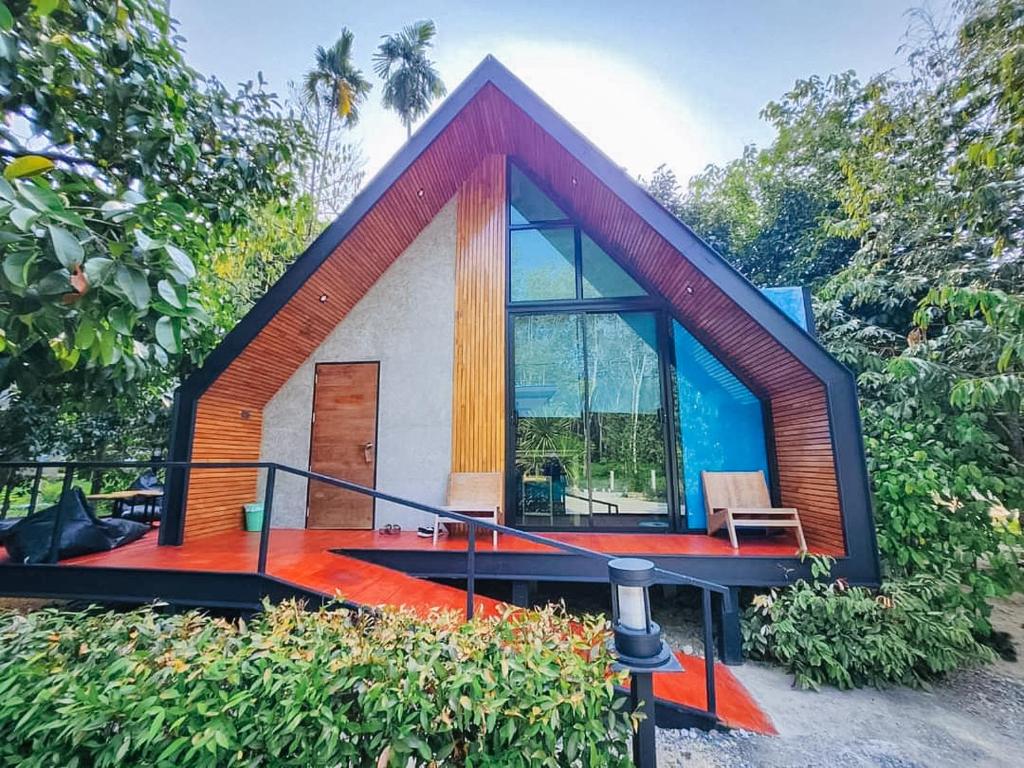 ein kleines Haus mit einem großen Fenster und einer Terrasse in der Unterkunft SkyHome Wat JD I- Khai Resort & Restaurant in Ban Wat Boek