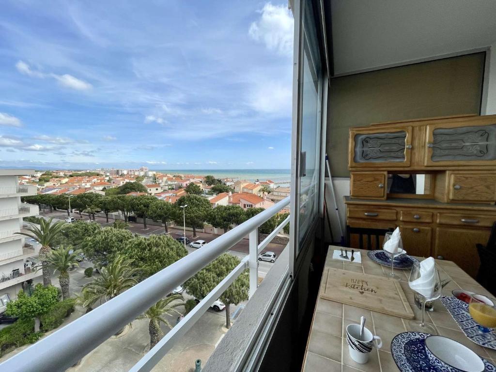 un balcon avec une table et une vue sur une ville dans l'établissement Appartement à Saint-Cyprien avec Terrasse, Parking et Ascenseur - 5 couchages - FR-1-225D-191, à Saint-Cyprien