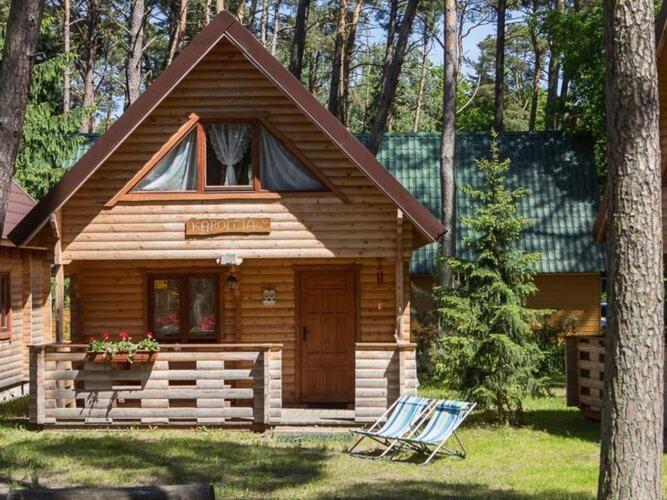 a log cabin with a sign on the front of it at Spacious and comfortable holiday houses close to the beach, Pobierowo in Pobierowo