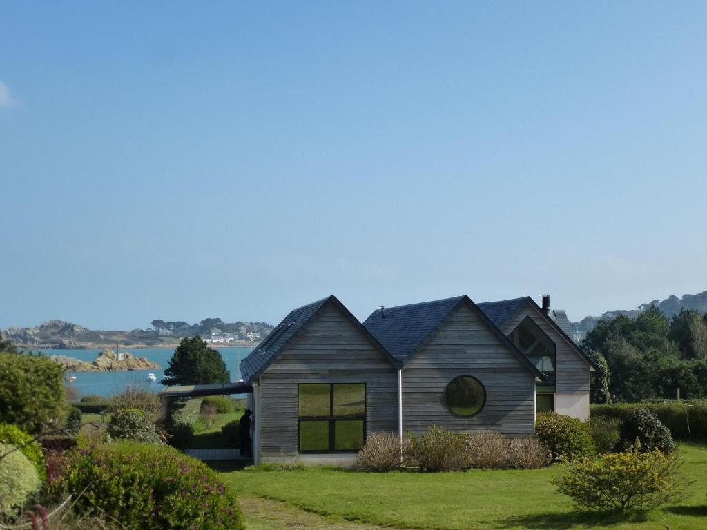 ein Haus mit Blick auf das Wasser in der Unterkunft Comfortable architect villa with magnificent view Plougasnou in Plougasnou