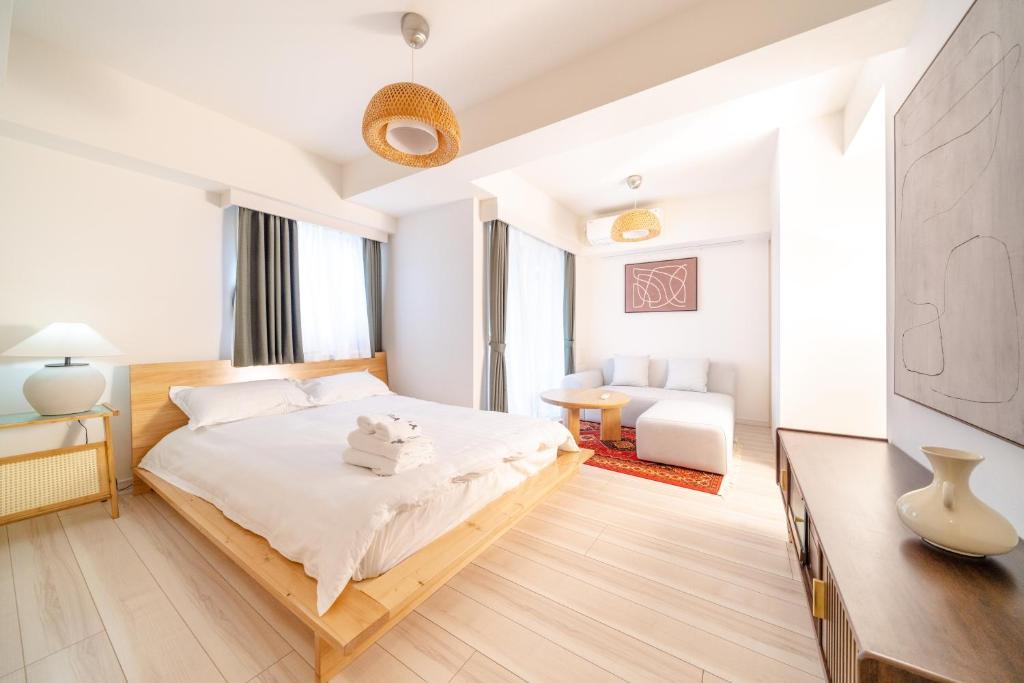 a white bedroom with a bed and a television at TORA HOTEL Sensoji 寅ホテル 浅草寺 in Tokyo