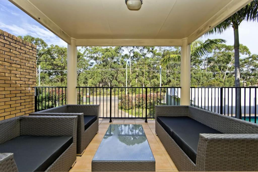 a screened in porch with two couches and a pool at Close to Little Beach and Shoal Bay Beach in Nelson Bay