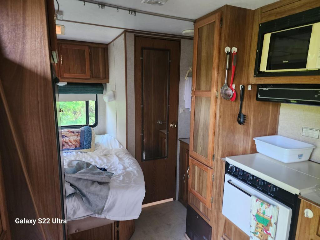 an interior view of an rv with a kitchen at Goin Bonanza Glamping Ranch in Hardy