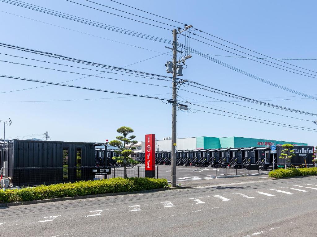 een lege parkeerplaats met een stel auto's bij HOTEL R9 The Yard Izumi in Izumi