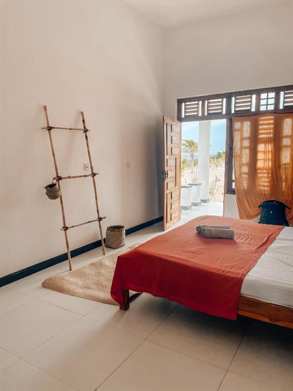 um quarto com uma cama com um edredão vermelho em Salty Alchemy em Arugam Bay