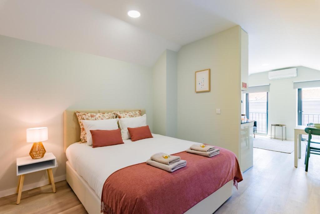 アヴェイロにあるTeatro à Vista - No coração do centro de Aveiroのベッドとタオル2枚のある寝室