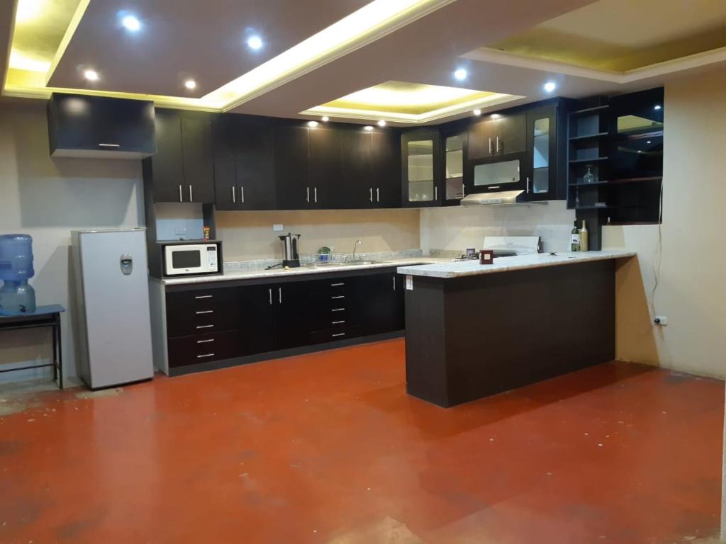 a kitchen with black cabinets and a white refrigerator at Casa Elenita in San Juan La Laguna