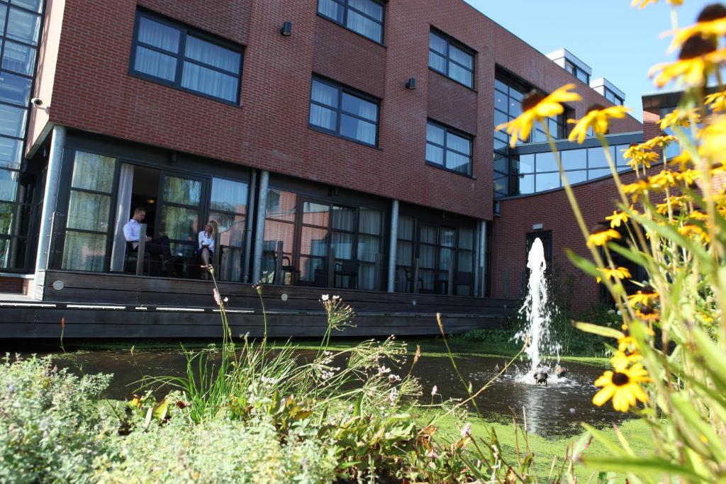 a building with a fountain in front of a building at Hotel Mijdrecht Marickenland in Mijdrecht