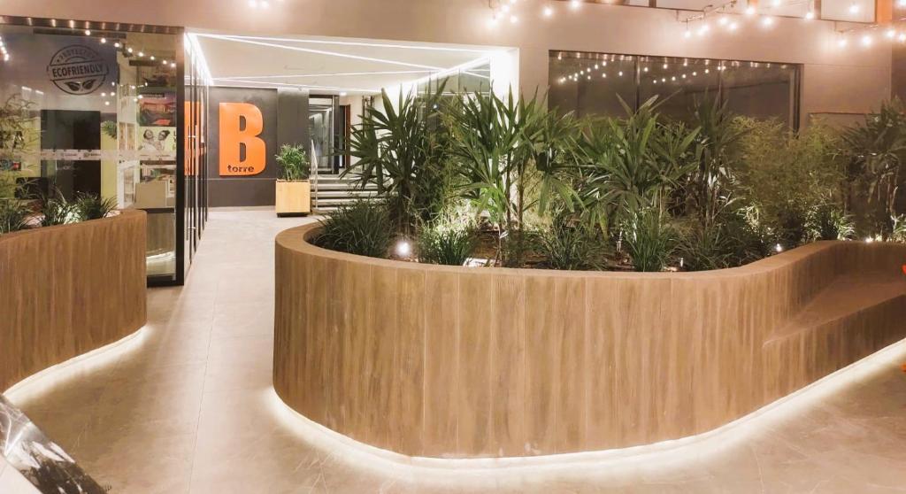 a lobby with a large planter with plants in it at LA POSADA de GUILLE 2 in Lima