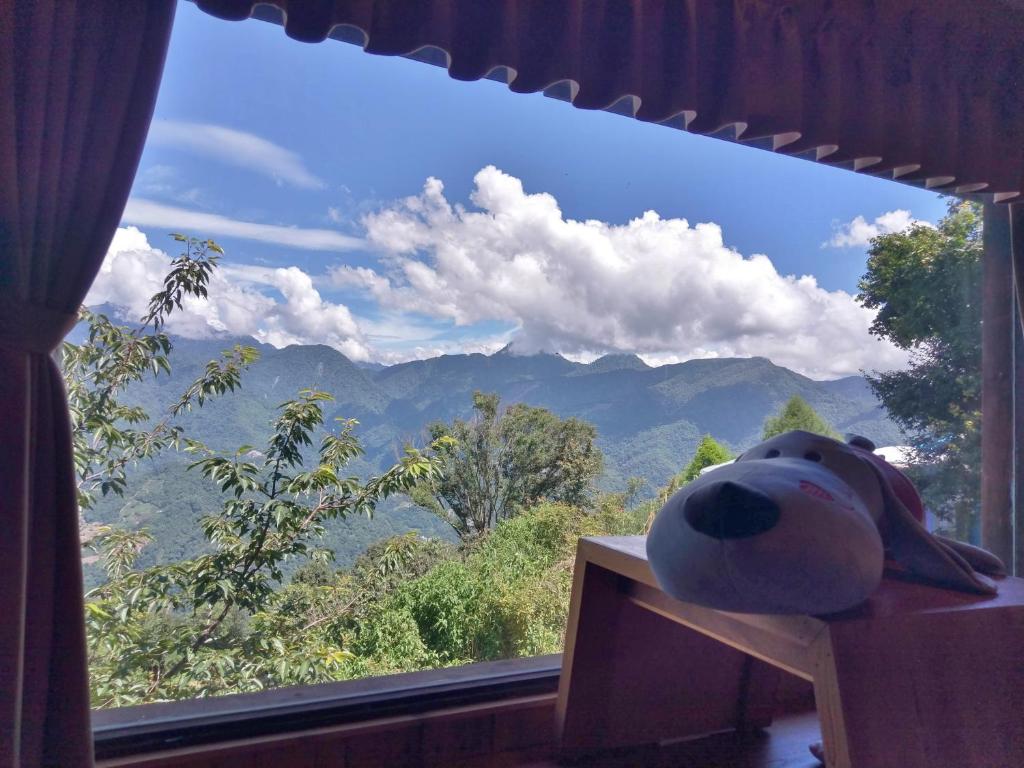 a teddy bear sitting on a table in front of a window at Shiyai Taoyuan in Ren&#39;ai