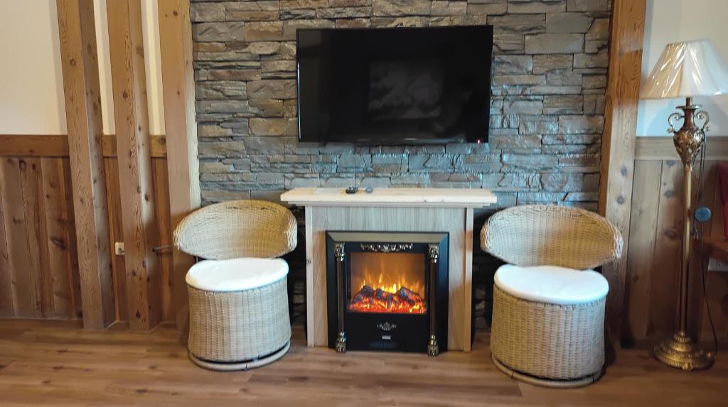 a living room with two chairs and a fireplace at Shiyai Taoyuan in Ren&#39;ai