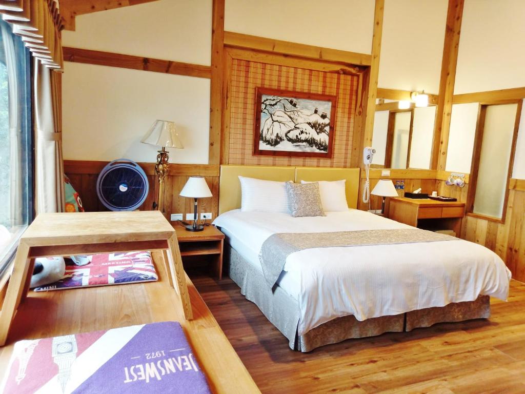 a bedroom with a bed and a desk and a bed sidx sidx sidx at Shiyai Taoyuan in Ren&#39;ai
