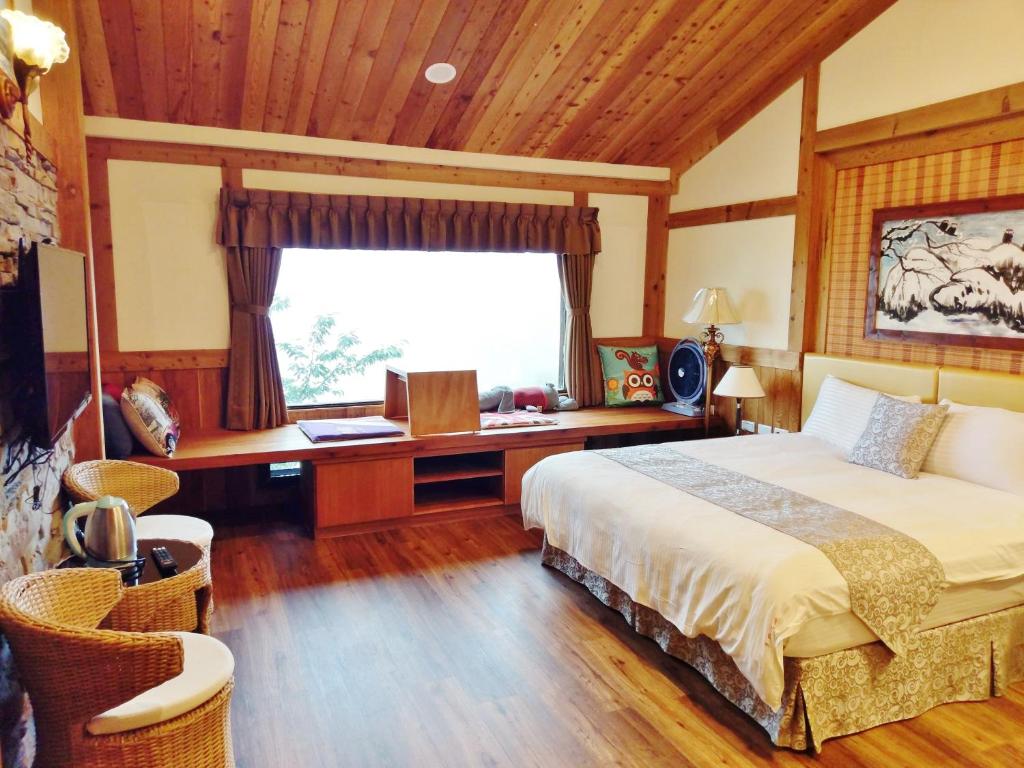 a bedroom with a bed and a desk and a window at Shiyai Taoyuan in Ren&#39;ai