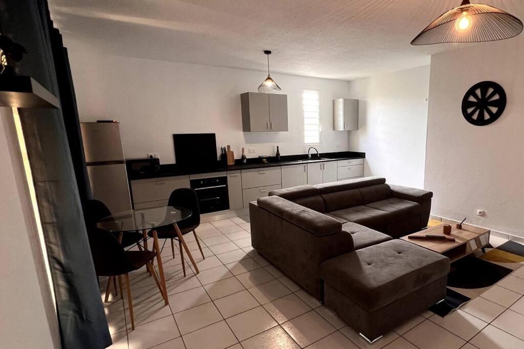 a living room with a couch and a table at Appartement T3 spacieux in Montjoly