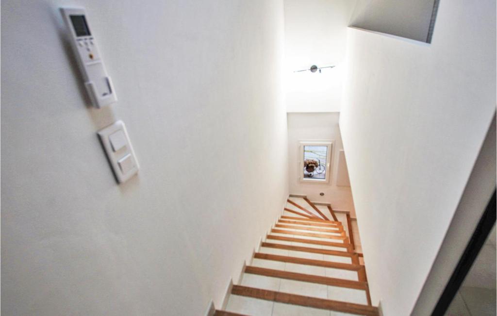 a hallway with a staircase with white walls at Cozy Home In Merindol With Outdoor Swimming Pool in Mérindol