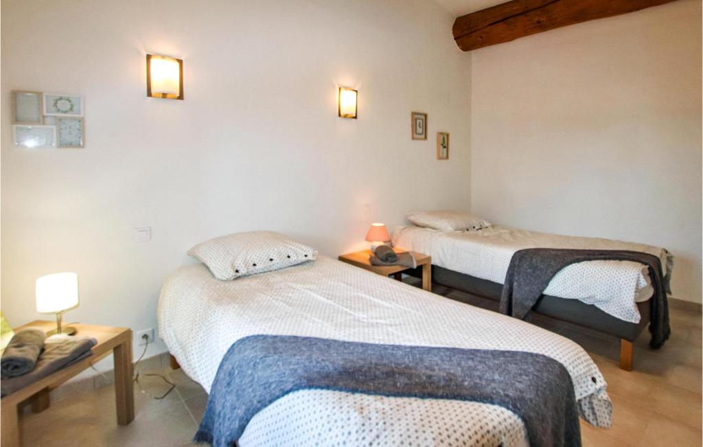 a room with two beds and two lamps on the wall at Cozy Home In Merindol With Outdoor Swimming Pool in Mérindol