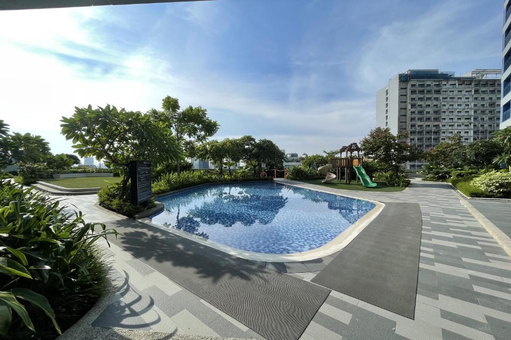 - une piscine dans un parc avec une aire de jeux dans l'établissement Luxe Air Residences by Makati, à Manille