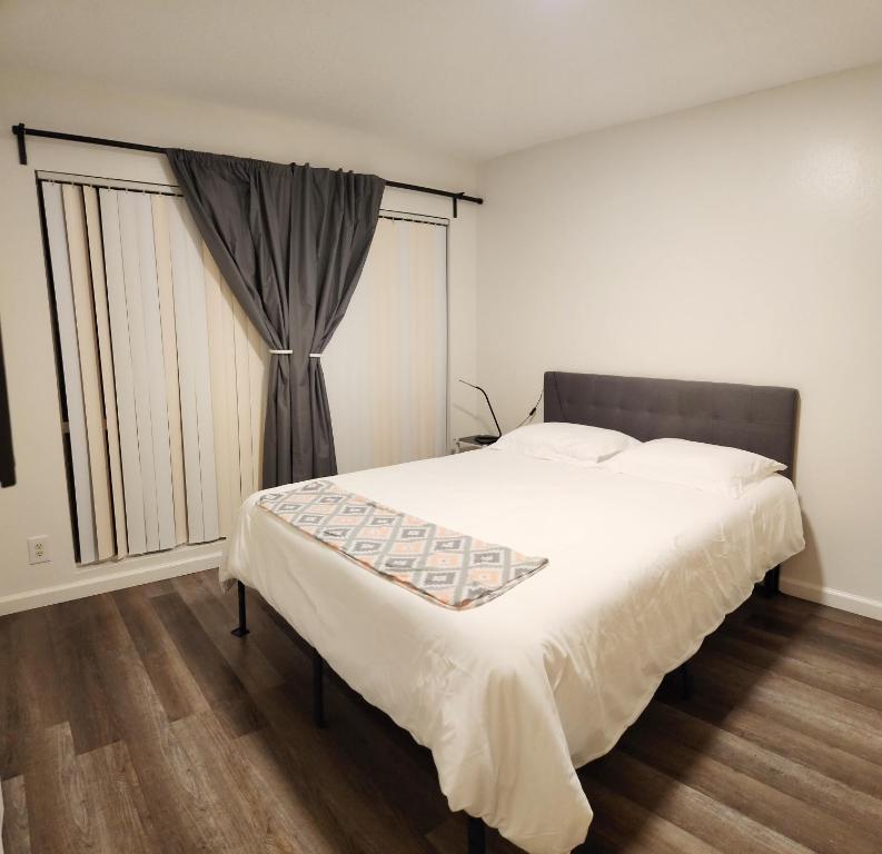 a bedroom with a bed and a large window at Centrally Located, 4x Queen, 300 MBPS Internet with Backyard! in Hemet