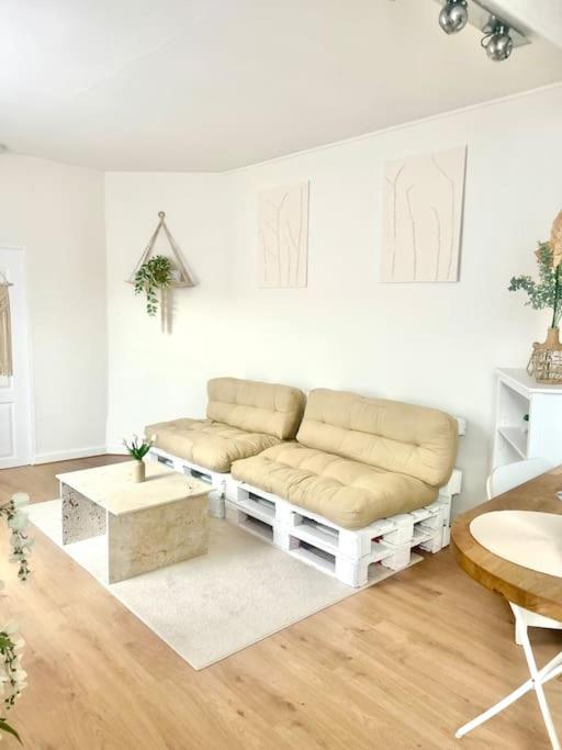 a white living room with a couch and a table at F2 Bohémien au centre ville in Corbeil-Essonnes