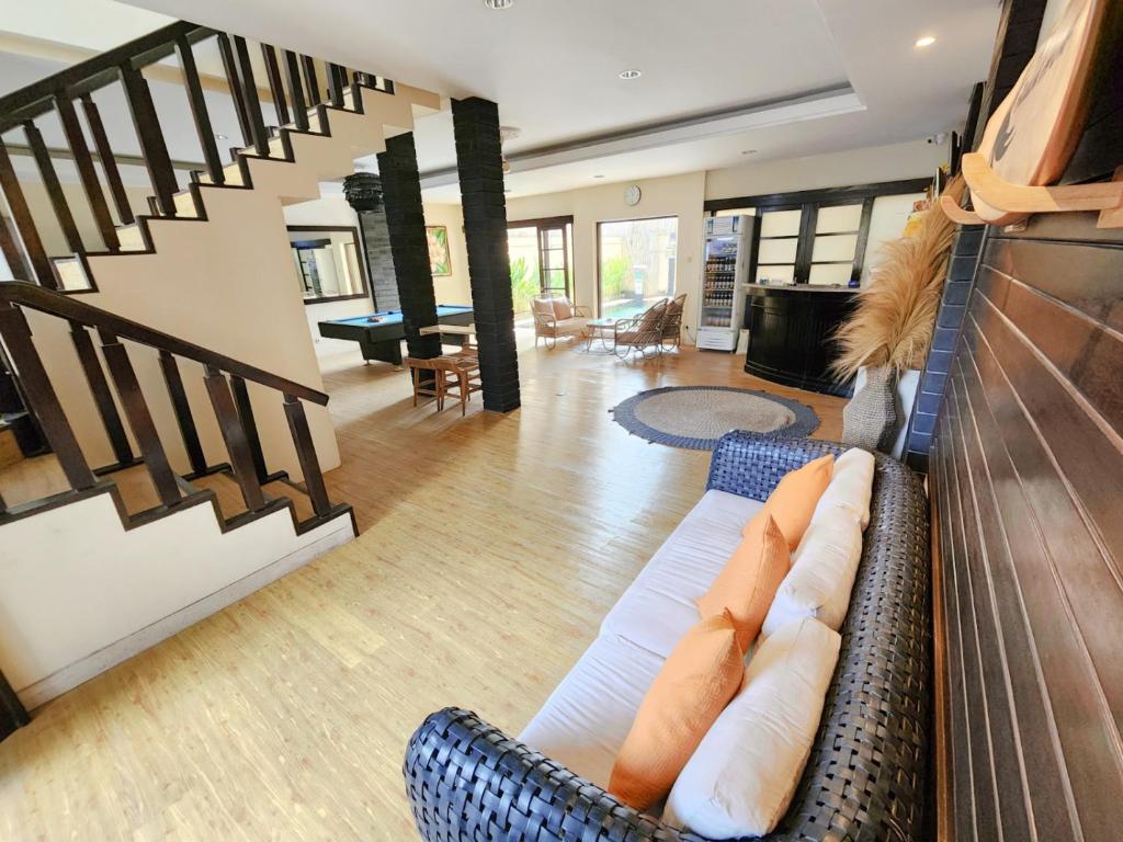 a living room with a couch and a staircase at Kent Beach House in Canggu