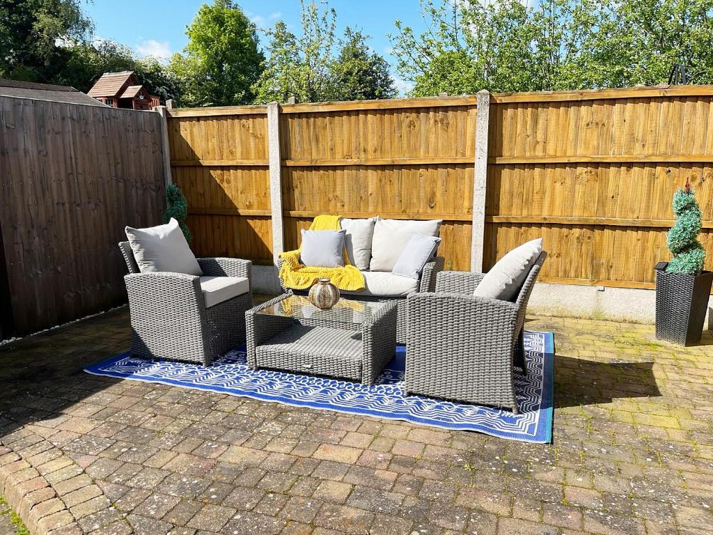 a patio with two chairs and a table and a fence at Robins Nest in Edwinstowe