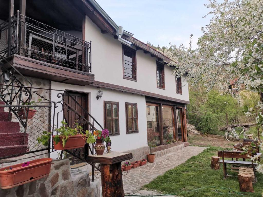 una casa blanca con una mesa en el patio en Къща за гости Старата череша село Раждавица en Rzhdavitsa