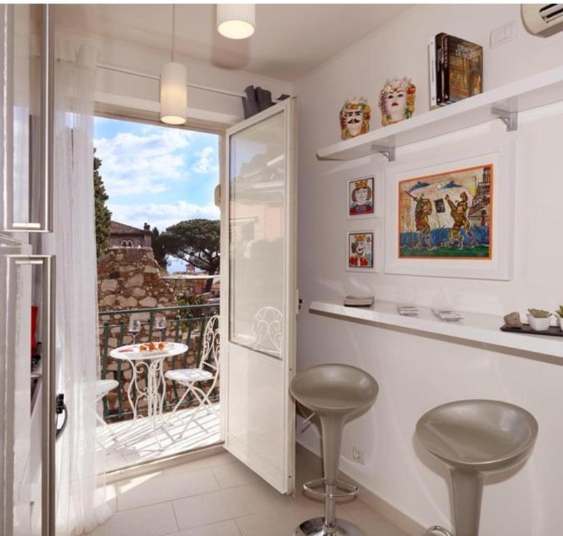 Camera dotata di balcone con tavolo e sgabelli. di Casa Christine a Taormina