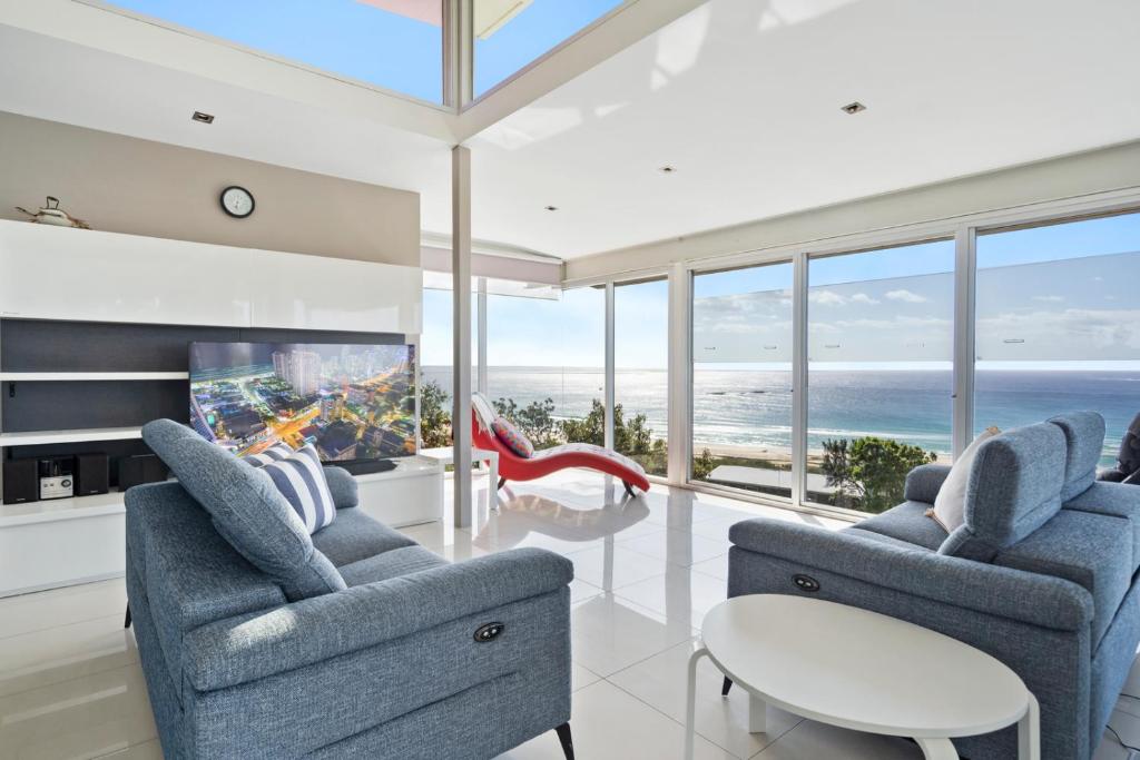 a living room with two chairs and a tv at Allure in Point Lookout