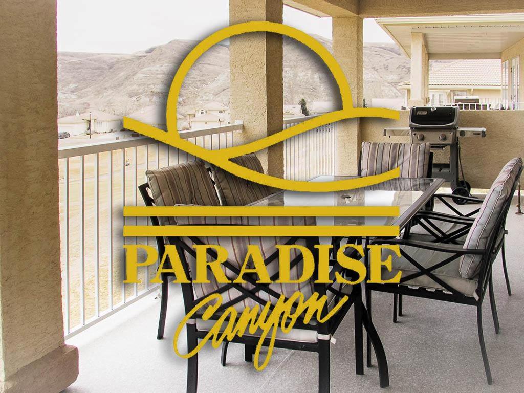 un tavolo e sedie su un balcone con simbolo giallo di Paradise Canyon Golf Resort, Signature Condo 382 a Lethbridge