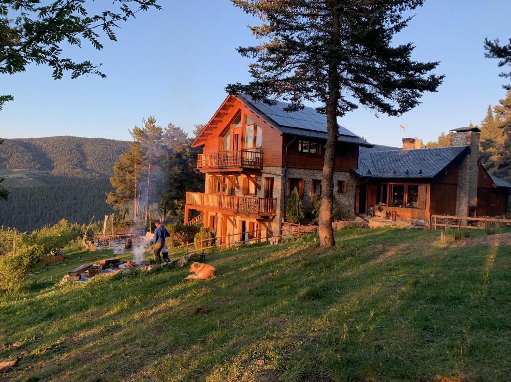 um homem parado em frente a uma casa em Minds & Mountains Eco Lodge em La Molina