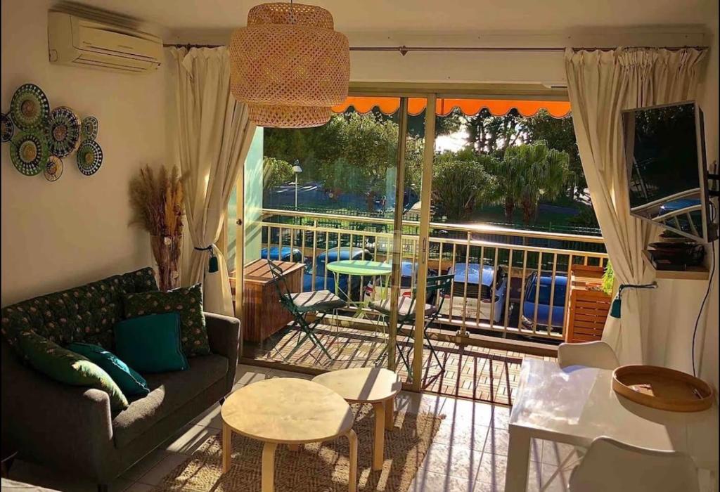 d'un salon avec un canapé et un balcon. dans l'établissement Le Bleuette - Festivals 10min - face plages !, à Cannes