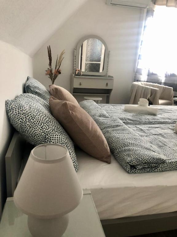 a bedroom with a bed with pillows and a lamp at Aniiza apartman in Örvényes