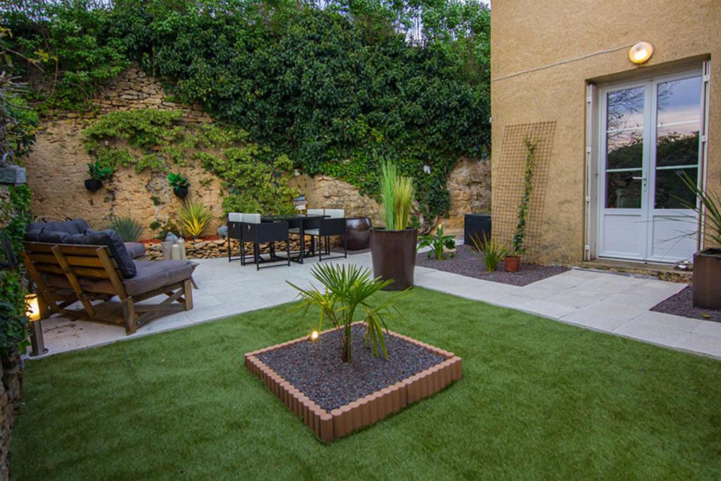 - un jardin avec une terrasse dotée d'une table et de chaises dans l'établissement Nessmann, à Sarlat-la-Canéda
