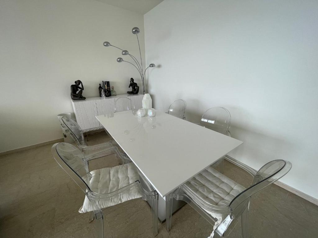 einen weißen Esstisch mit 4 Stühlen in der Unterkunft F1 Exclusive 100-sqm Monaco Apartment with Private Parking in Monte Carlo