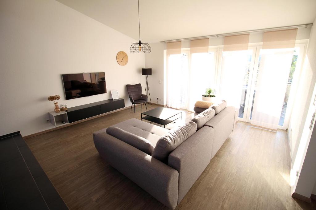 salon z kanapą i telewizorem w obiekcie Hochwertige Maisonette Wohnung - Boardinghouse Gottmadingen w mieście Gottmadingen