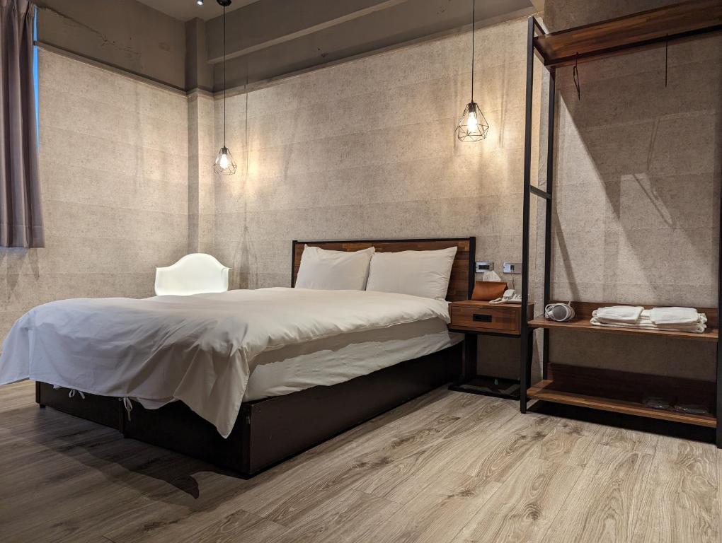 sypialnia z dużym łóżkiem i stolikiem nocnym w obiekcie Puremeworld Hotel w Tajpej