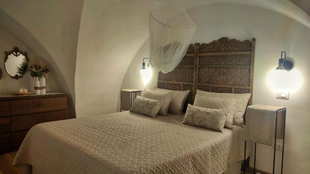 1 dormitorio con 1 cama grande con sábanas y almohadas blancas en La Nghioscia, en Grottaglie