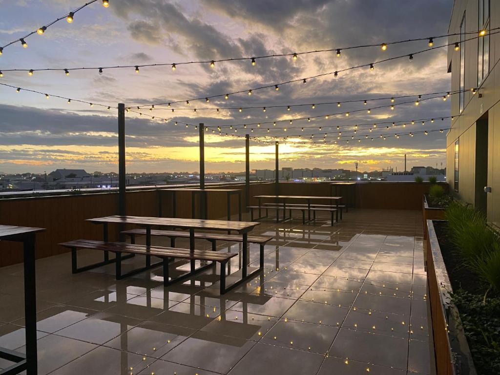 a rooftop patio with tables and lights on a building at Cityscape in Christchurch