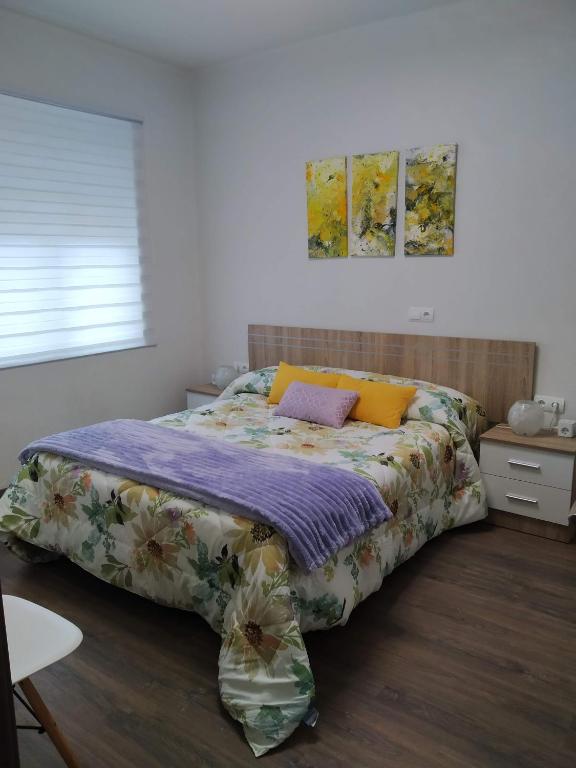 a bedroom with a large bed with colorful sheets at Apartamento Casco Antiguo Ponferrada in Ponferrada