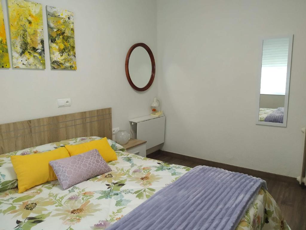 a bedroom with a bed with yellow and purple pillows at Apartamento Casco Antiguo Ponferrada in Ponferrada