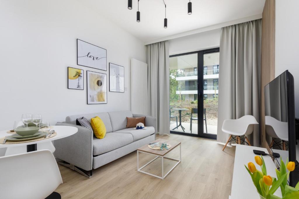 sala de estar con sofá y TV en Shellter Premium Apartment Beachside by Renters Prestige en Rogowo