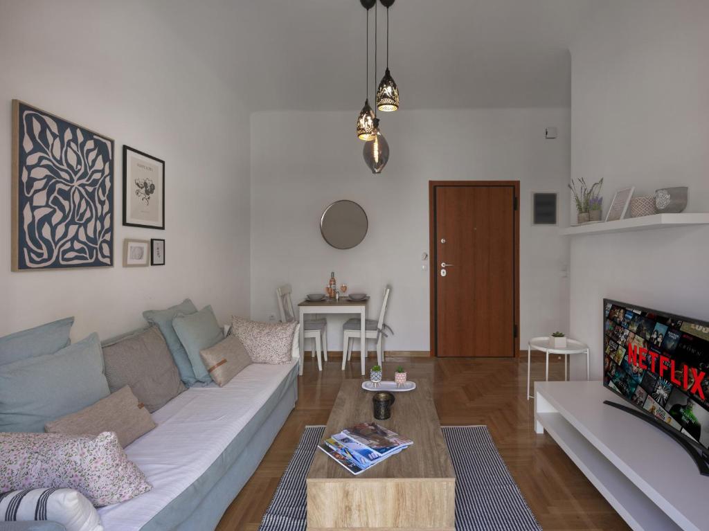 uma sala de estar com um sofá e uma mesa em Beautiful Athenian apartment next to the center em Atenas