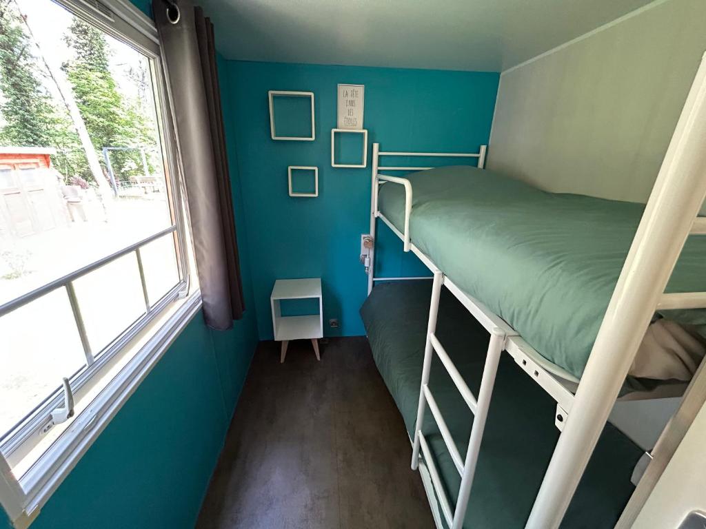 a bunk bed in a room with a window at LE ILÔ - camping la dune blanche in Camiers