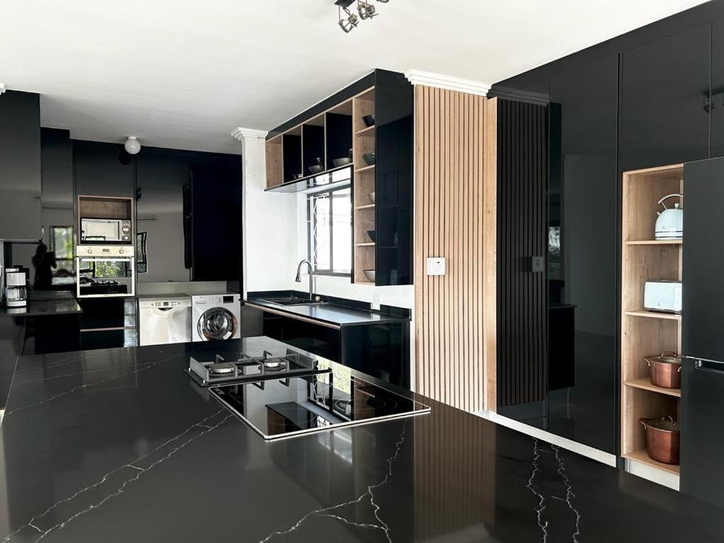 a kitchen with black cabinets and a black counter top at Luxury on 1B Patricia in Ballito